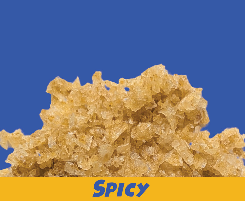 Close-up of a Scotch Bonnet chilli sea salt flakes with 'SPICY' text on a blue background